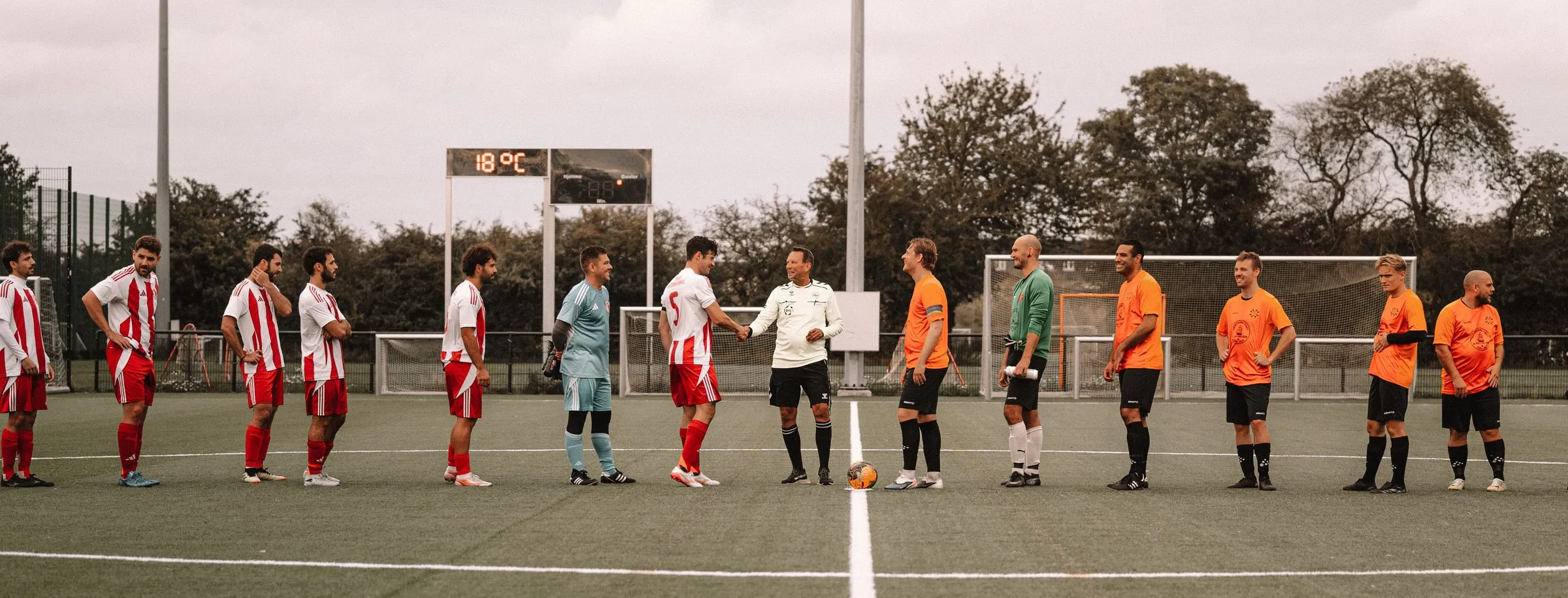 Two teams line up and shake hands with the referee before a match